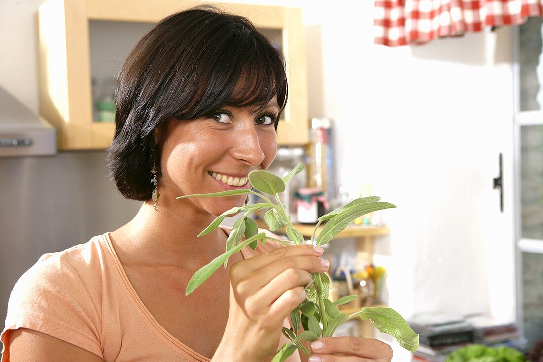 Young woman smelling sage