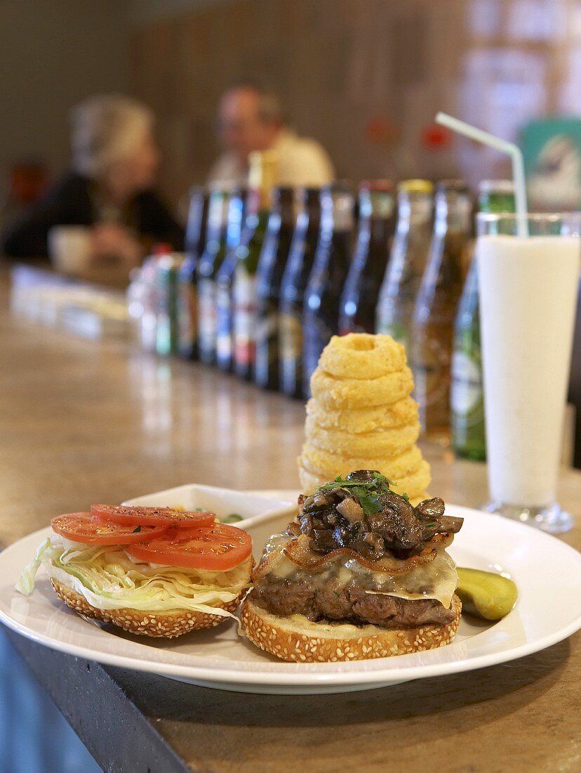 Cheeseburger mit Pilzen und Bacon im Restaurant