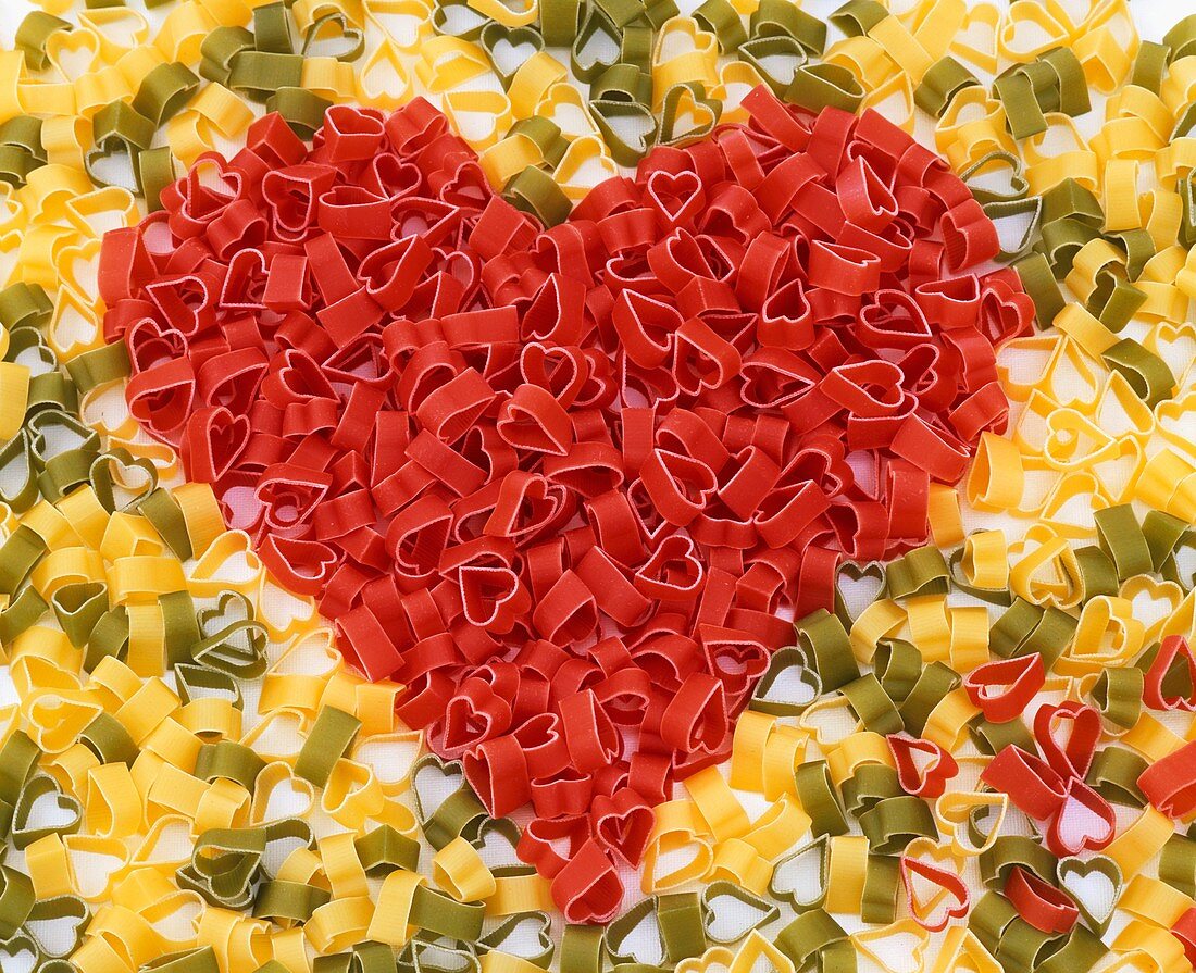 Red heart-shaped pasta forming a heart