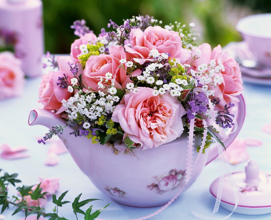Kleiner Strauss aus rosa Rosen und Schleierkraut in Teekanne