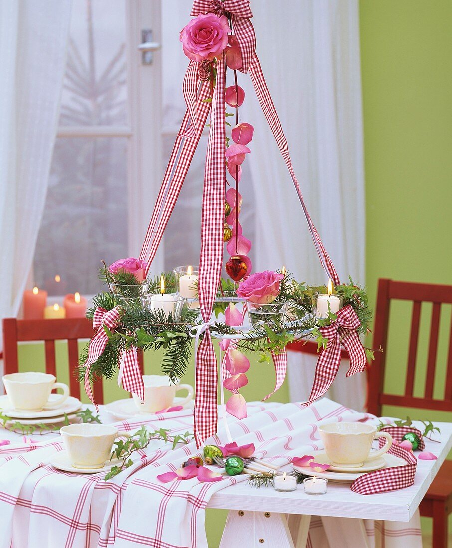 Hanging wreath of Douglas fir & roses above Christmas table