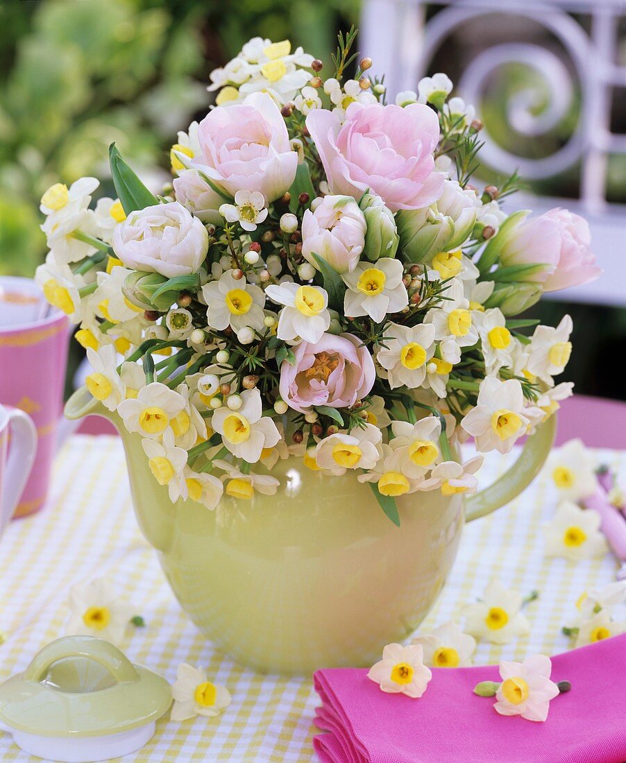 Strauss aus Tulpen, Narzissen, Waxflower in hellgrüner Kanne