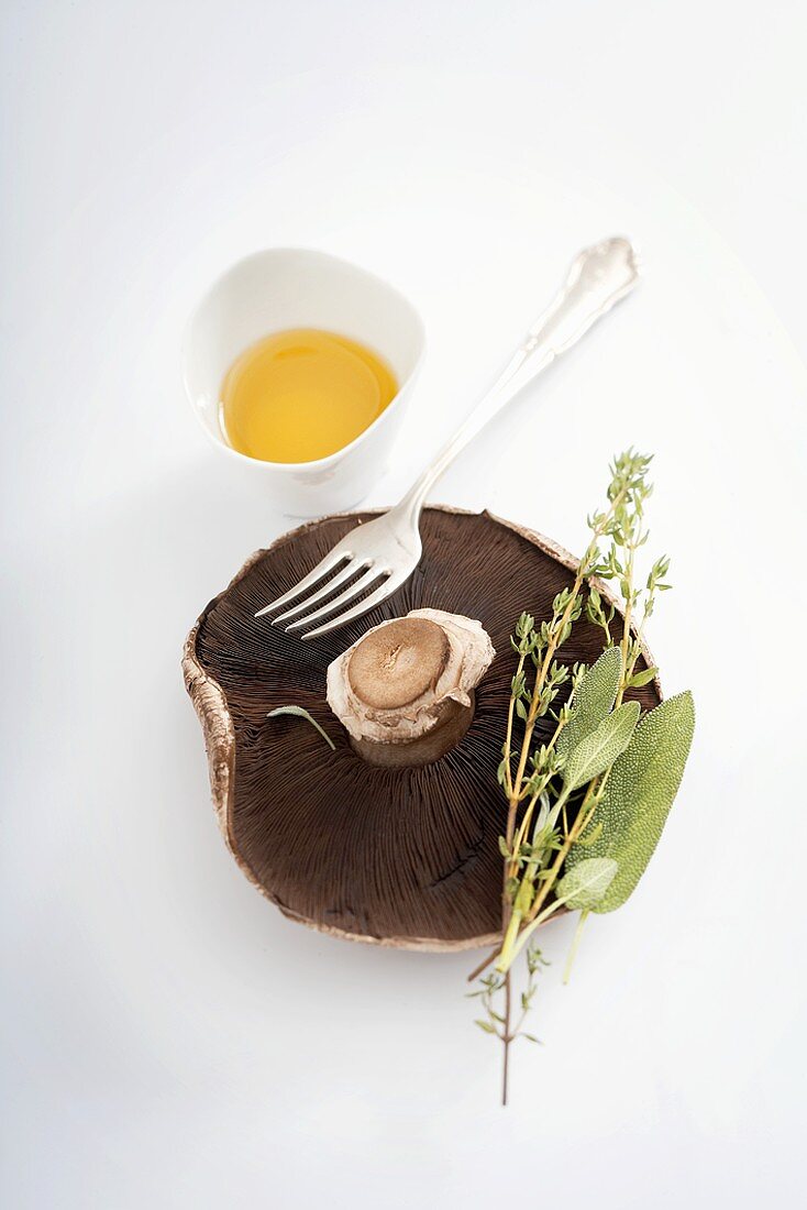 Stillleben mit Portobello-Pilz, Kräutern und Olivenöl