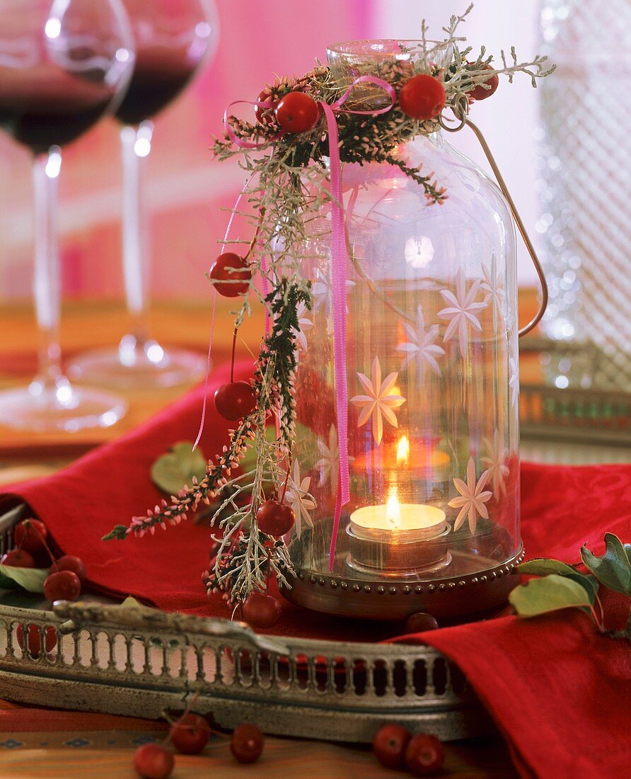 Windlight with garland of senecio, crab apples, heather