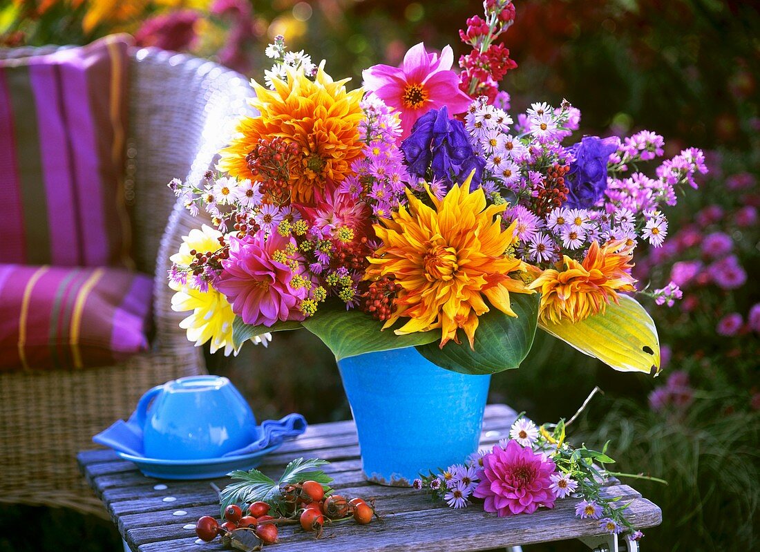 Autumnal arrangement of dahlias and asters on garden table