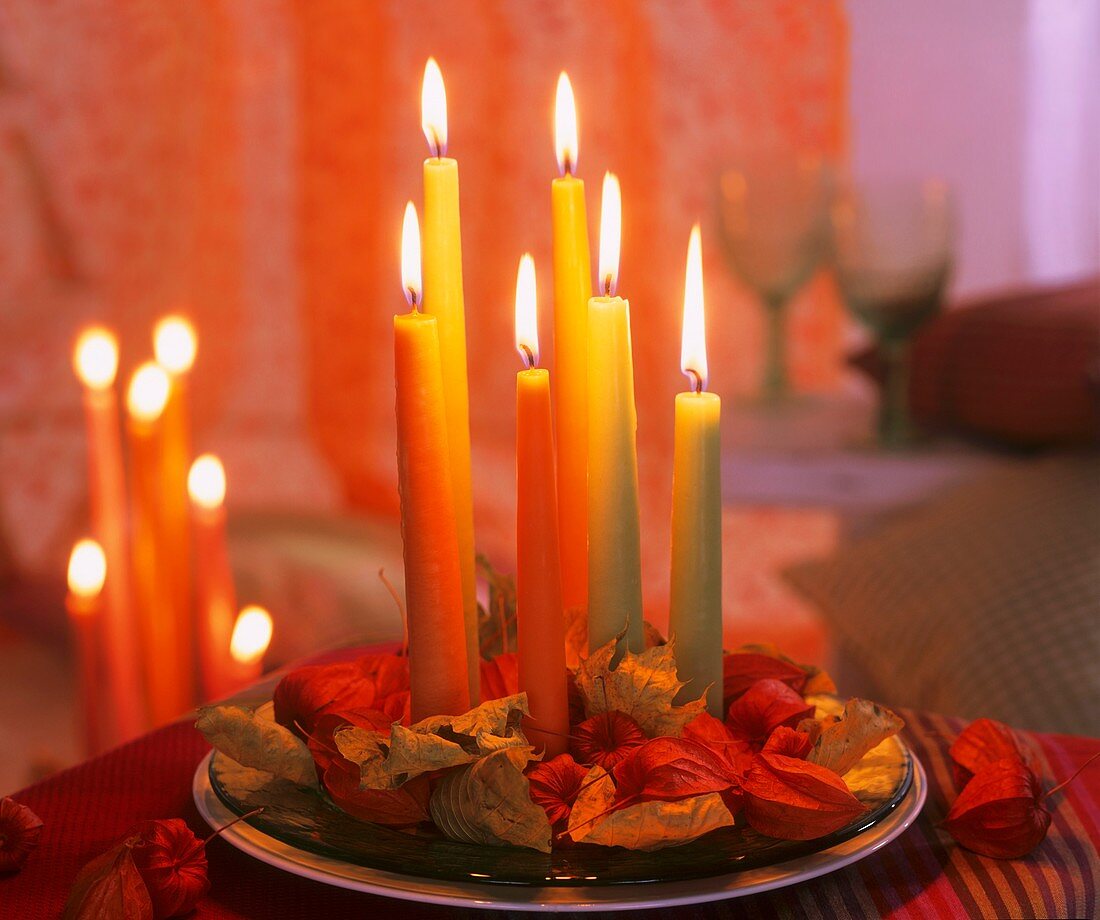 Candles on glass plate with Chinese lanterns & autumn leaves