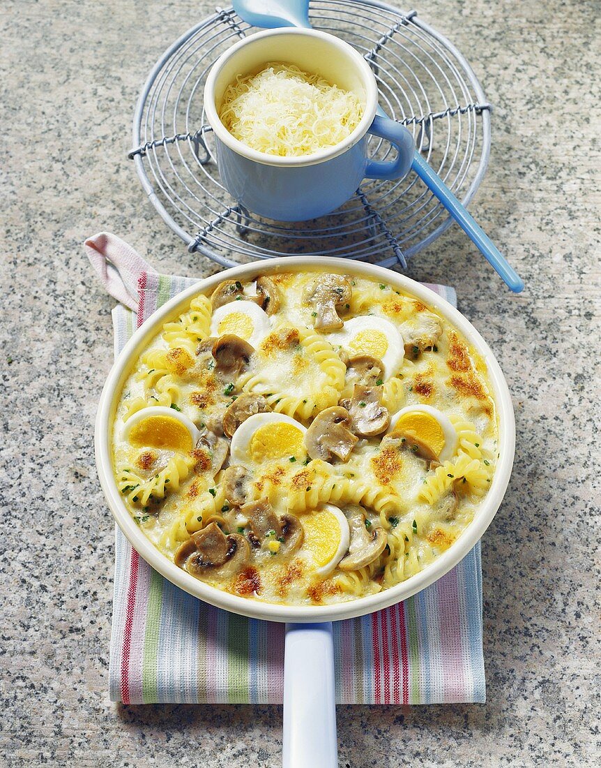 Pan-cooked pasta & mushroom dish with eggs & cheese topping