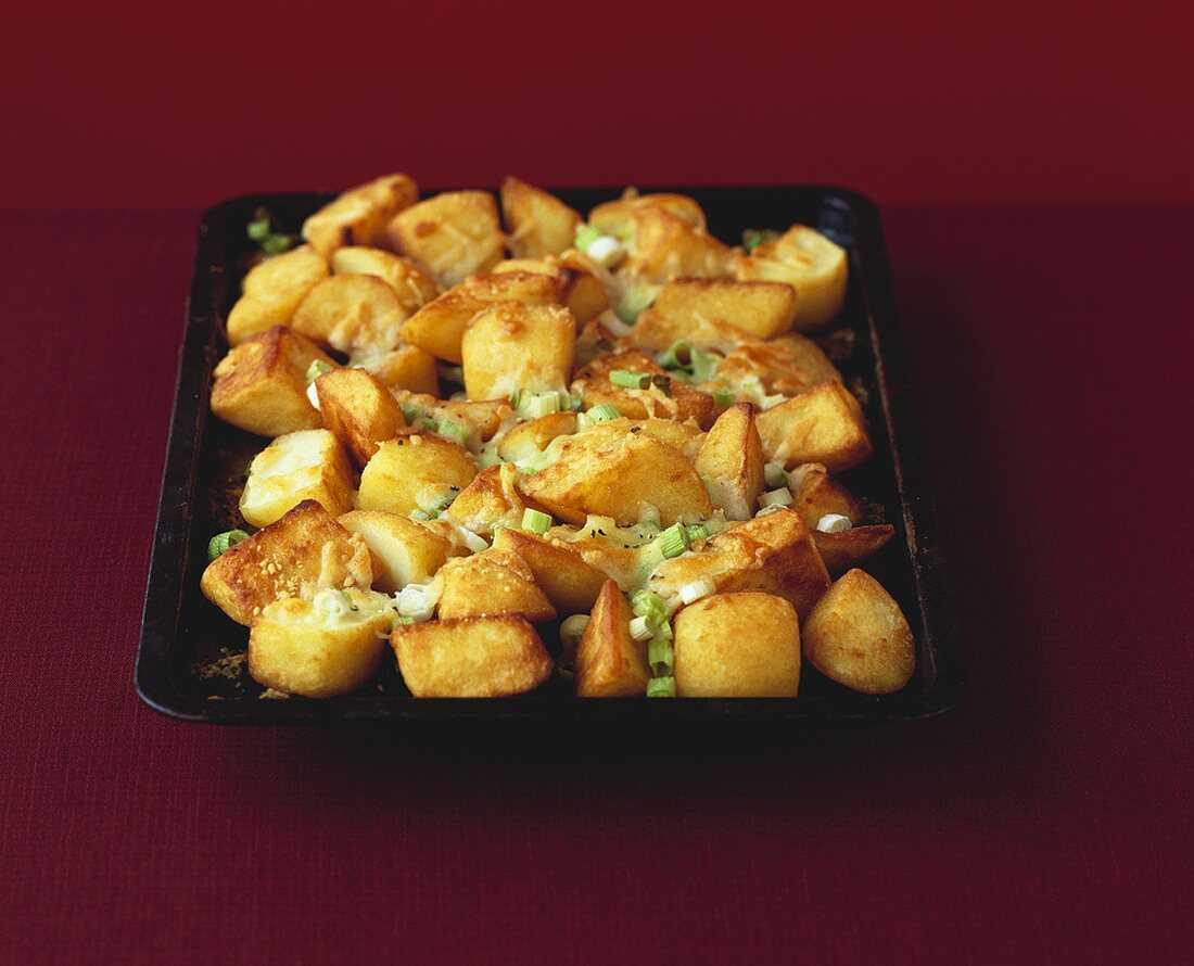Roast potatoes with melted cheese and spring onions