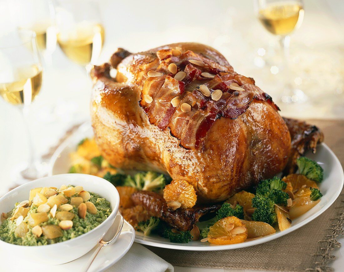 Roast duck with slices of bacon, oranges and broccoli