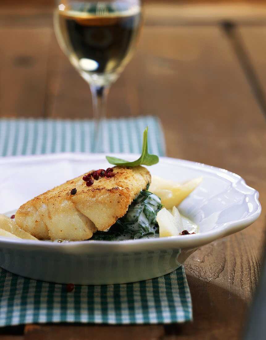 Fish fillet with pear slices on creamed spinach