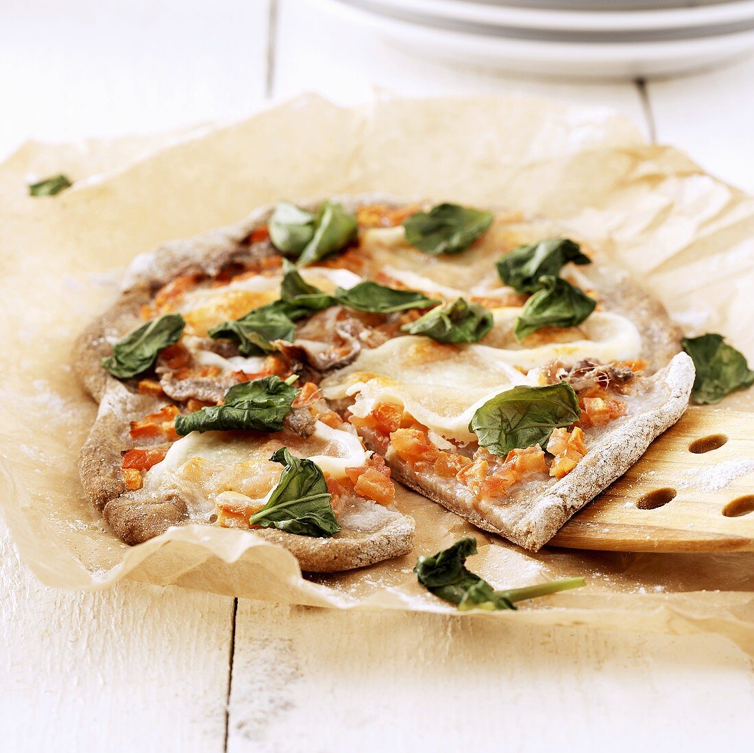 Home-made pizza with anchovies and basil leaves