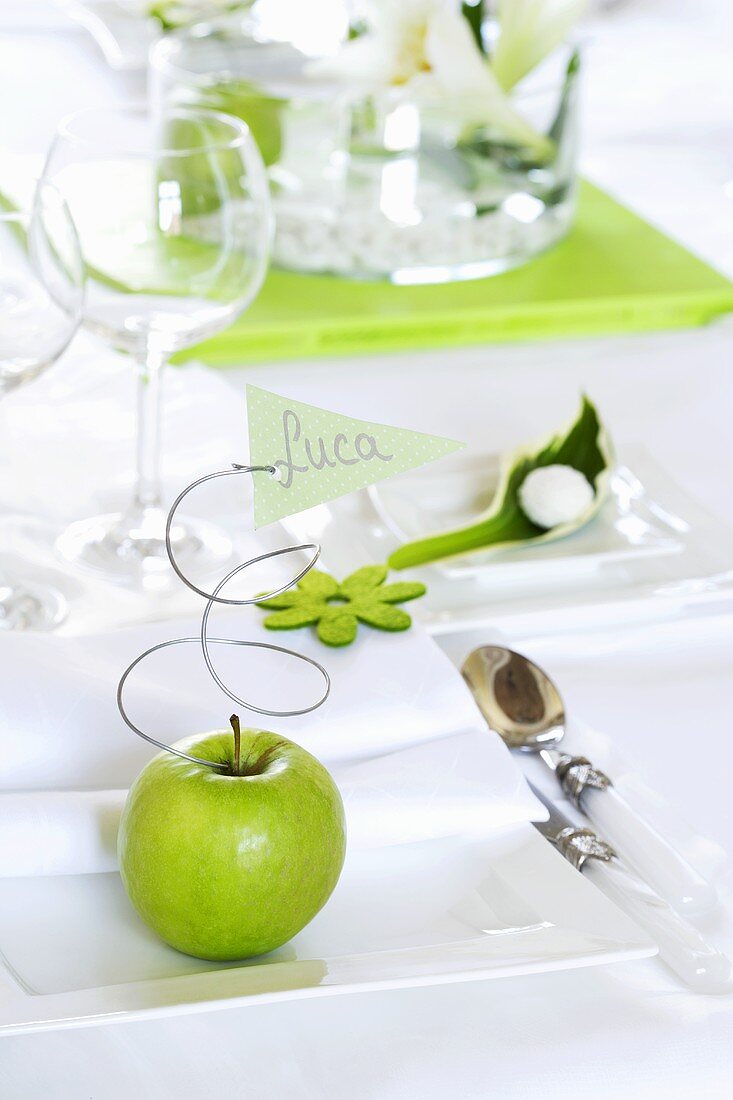 Green apple and place card on white plate