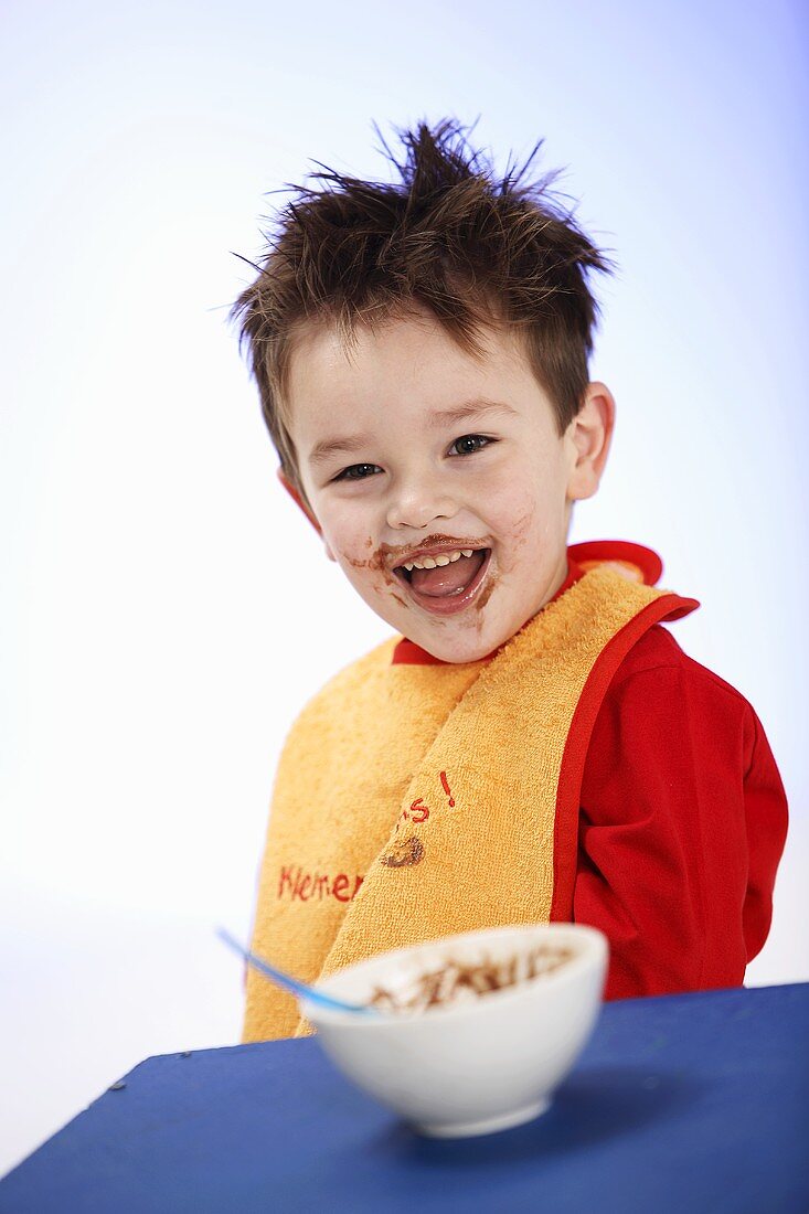 Kleiner Junge mit Lätzchen nach dem Essen