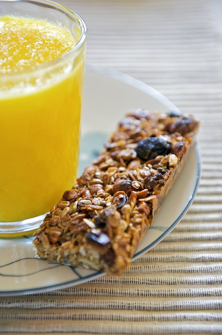 Granola-Riegel mit einem Glas Orangensaft