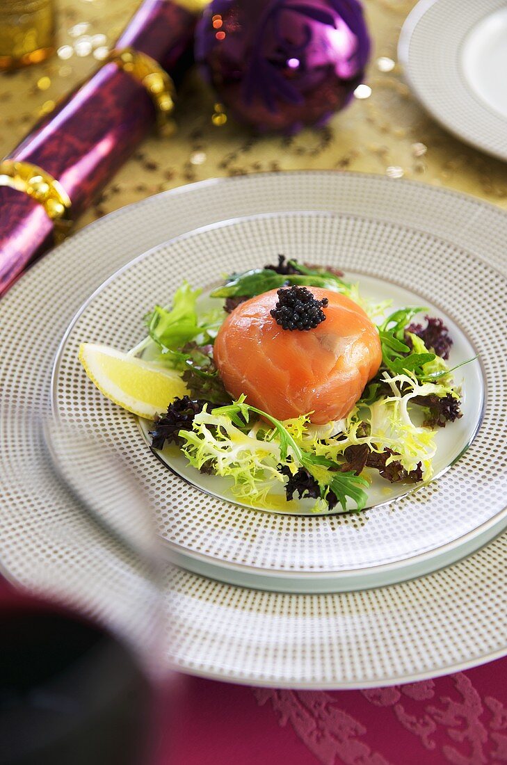 Crab salad wrapped in smoked salmon with caviar and salad leaves