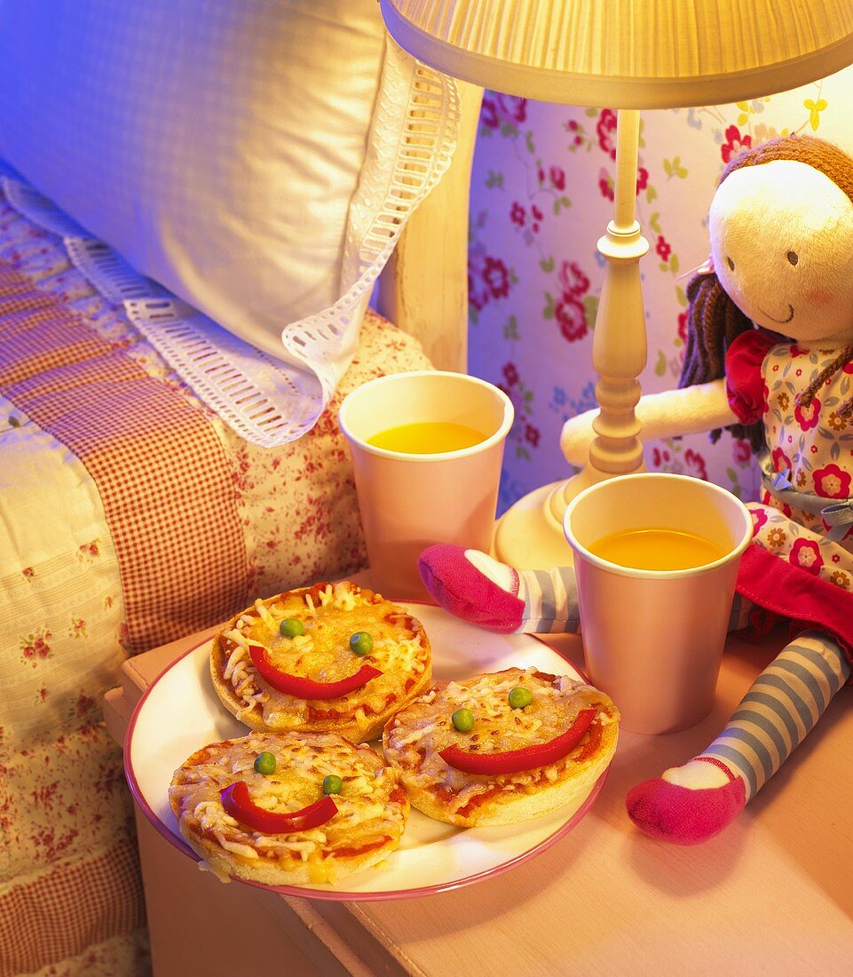 Minipizzen mit lustigen Gesichtern im Kinderzimmer