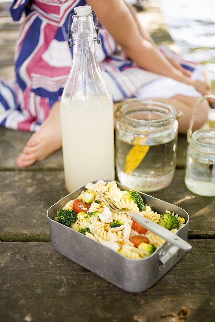 Chicken pasta salad in lunch box by sea