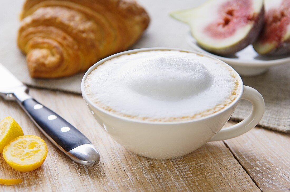 Milky coffee, croissant and fruit
