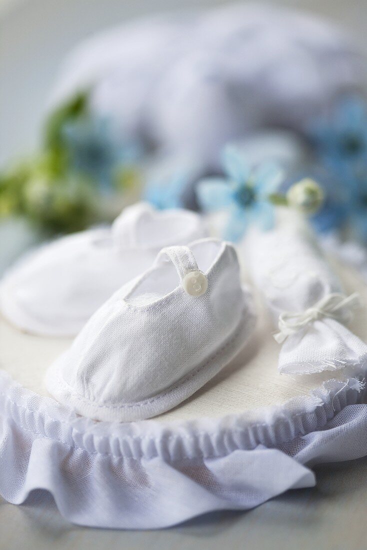 White baby shoes on cushion