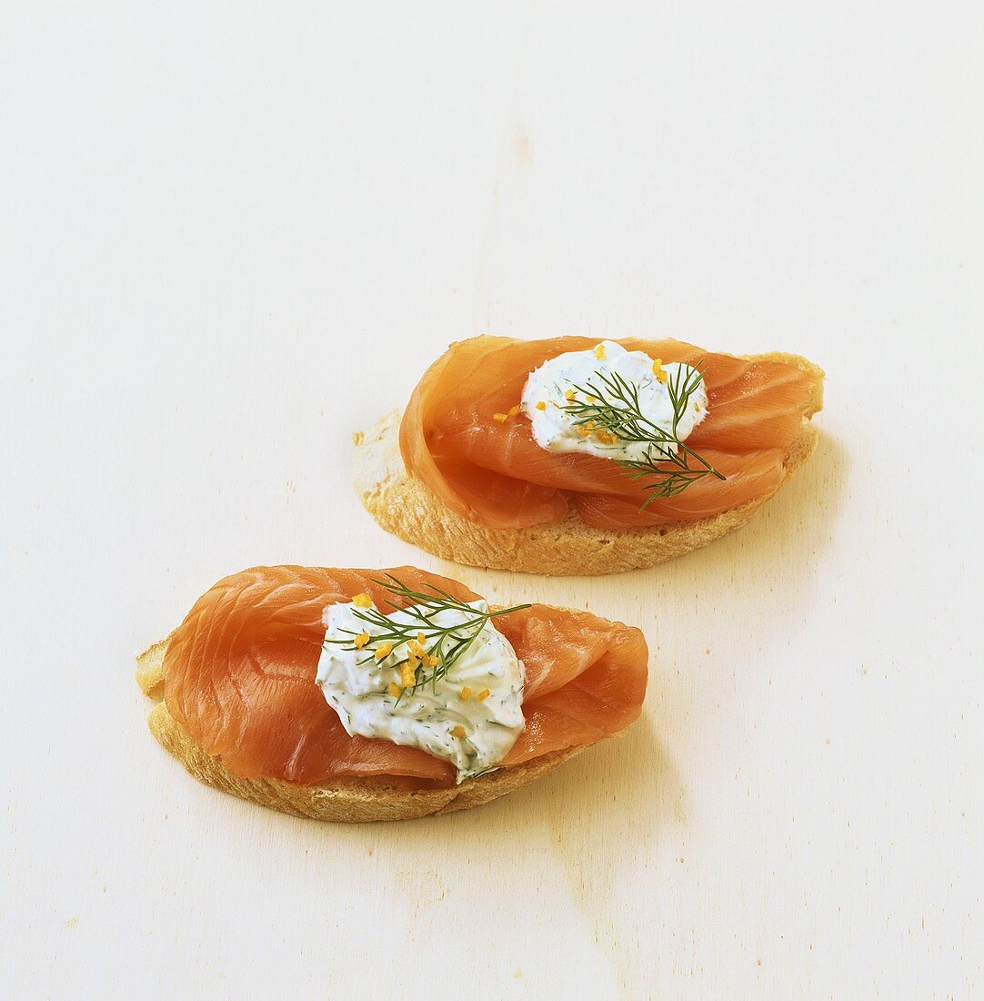 Two open smoked salmon sandwiches with dill cream