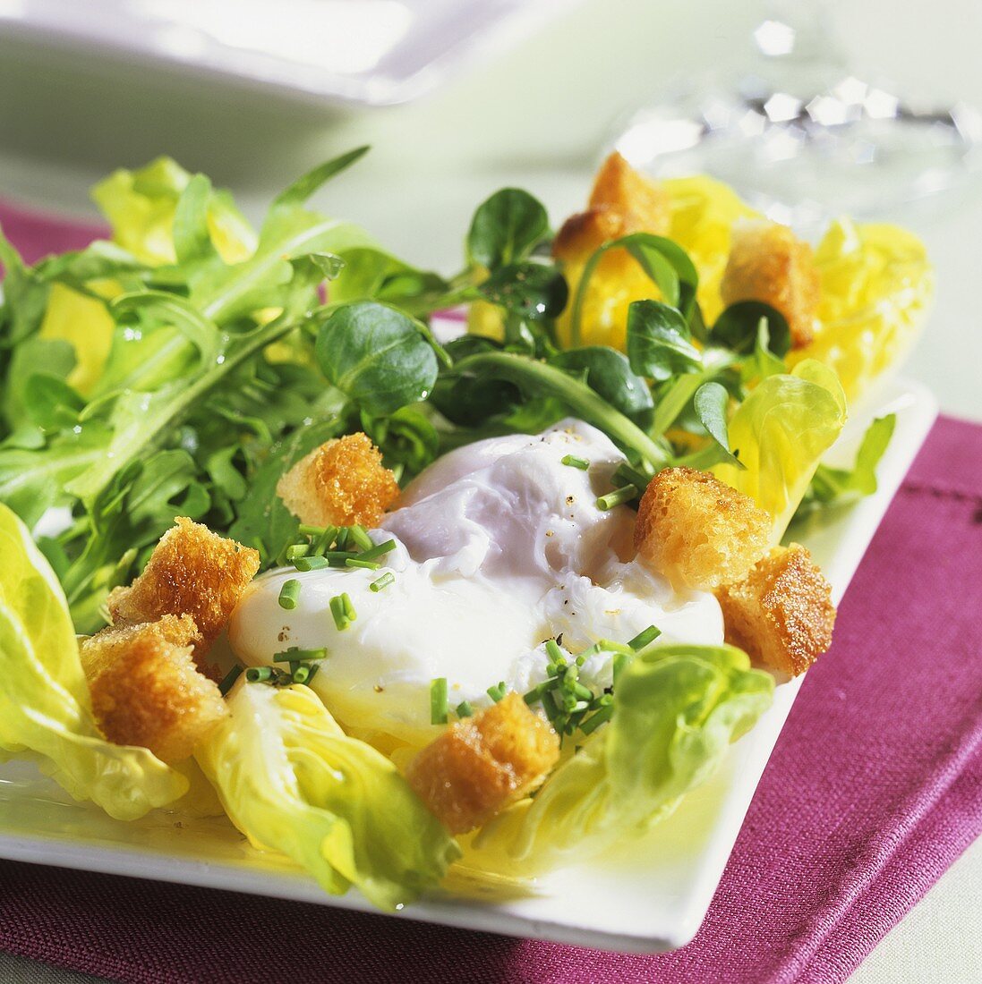 Salat mit pochiertem Ei und Brot