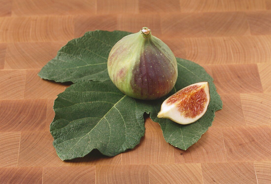 A fig with a piece of fig on a leaf
