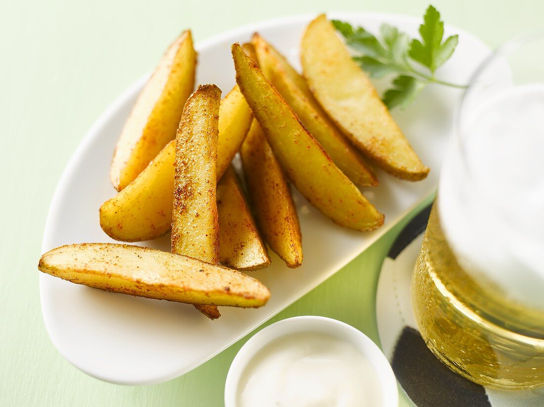 Potato wedges with a glass of beer and aioli