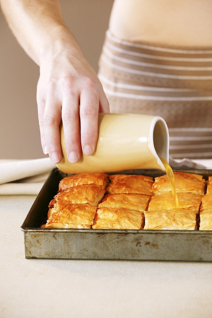 Baklava mit Sirup begiessen