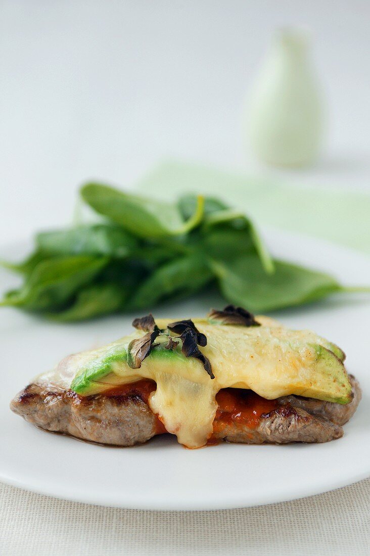 Veal steak with tomato sauce, avocado and melted cheese