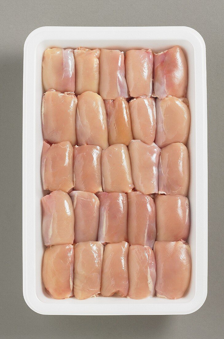 Boneless chicken thighs on plastic tray