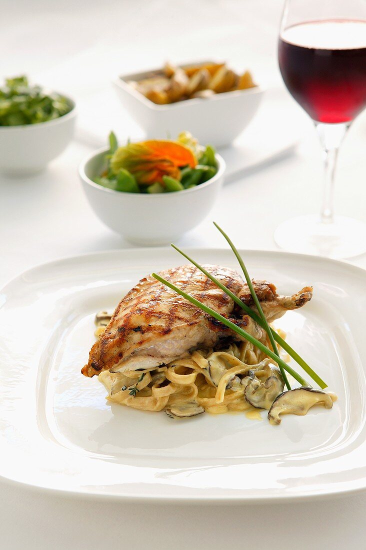 Chicken breast on ribbon pasta with mushrooms