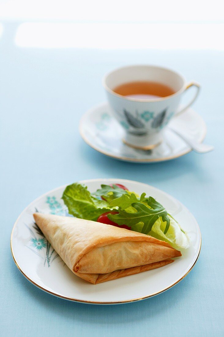 Filo pastry parcel with salad and a cup of tea