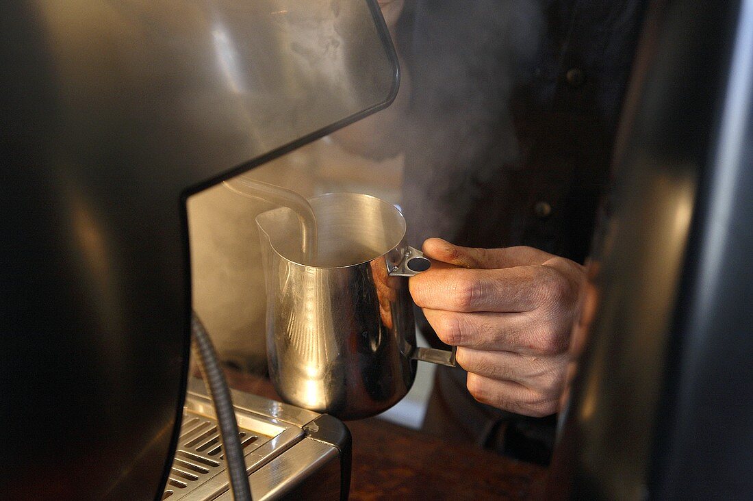 Frothing milk at espresso machine