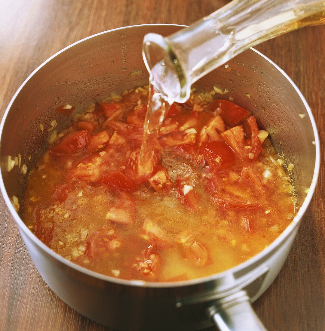 Tomatensauce zubereiten: Weißwein zugiessen