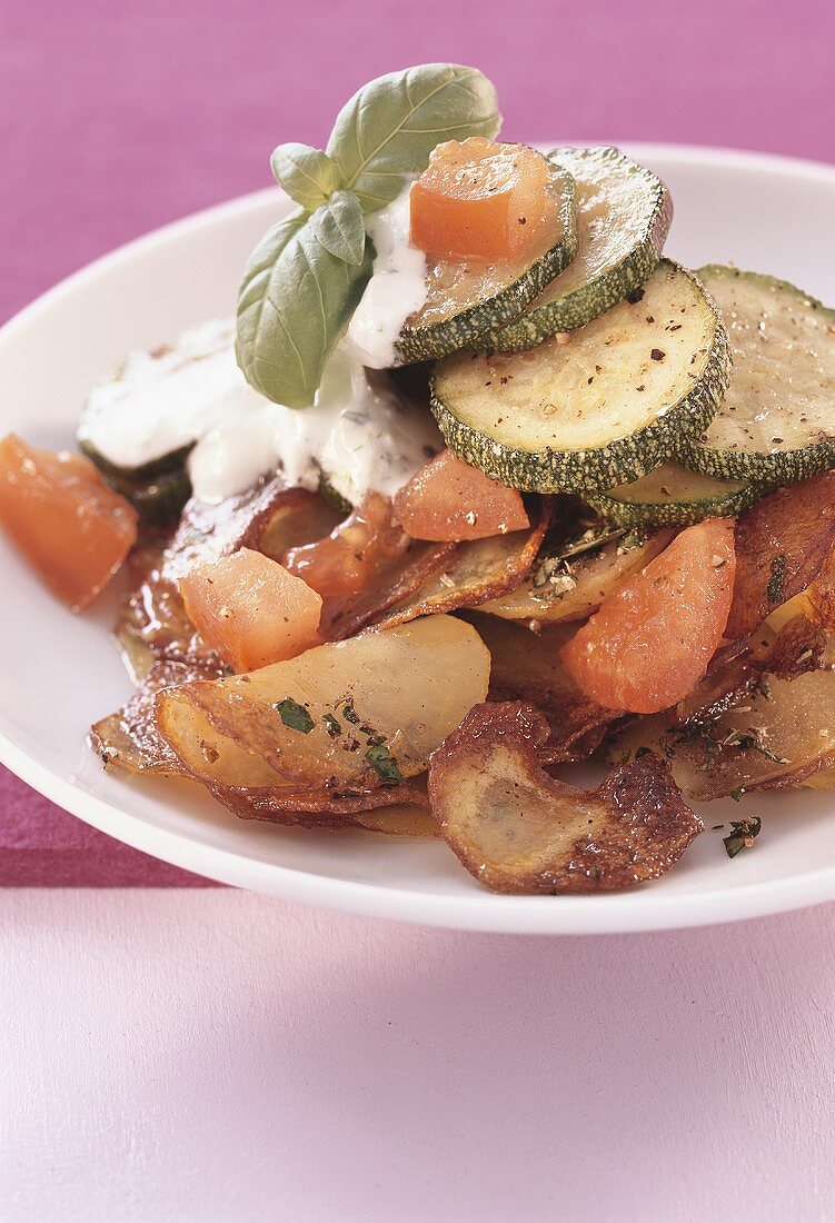 Fried potatoes with courgettes, tomatoes and sour cream