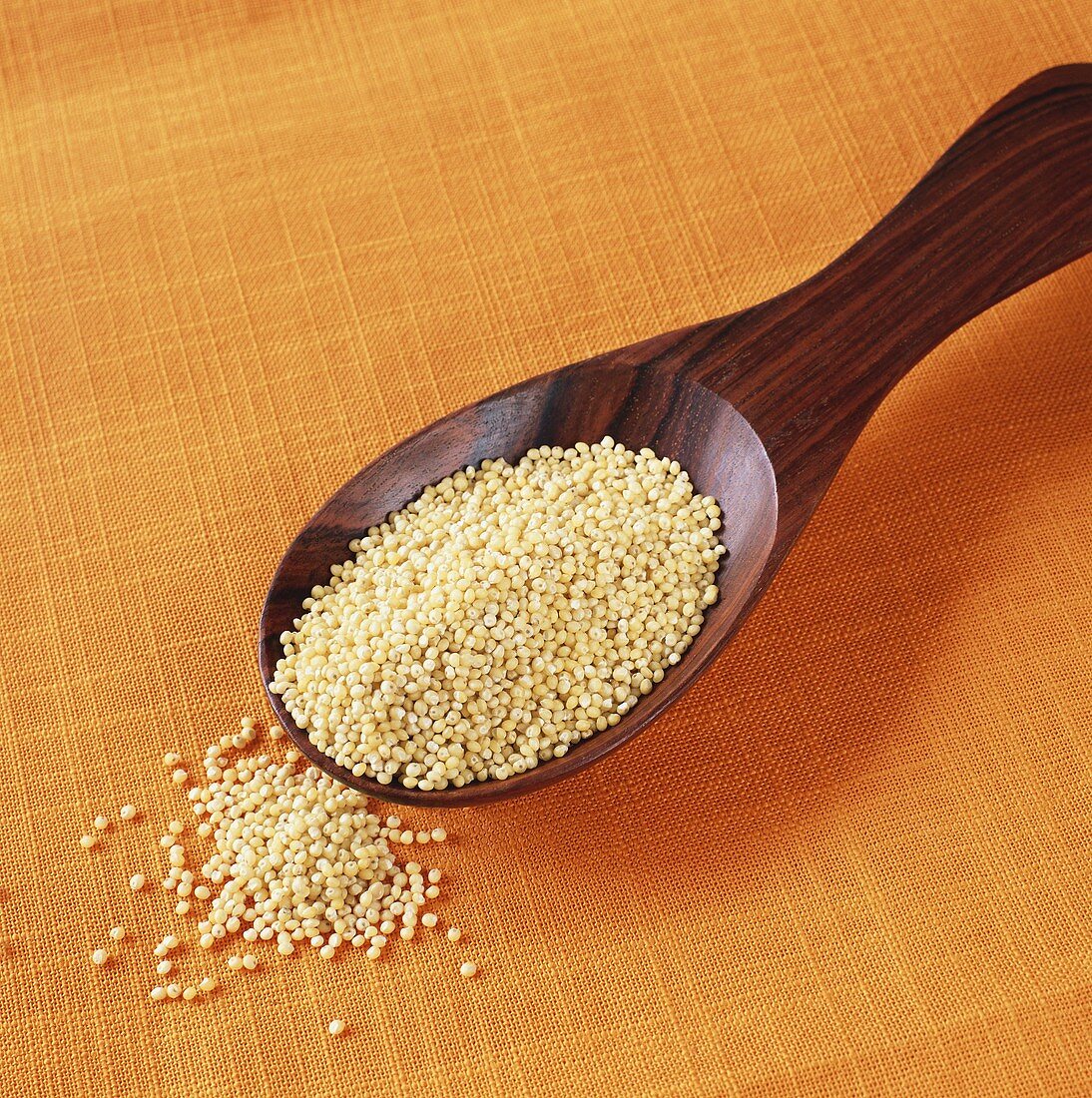 Millet in wooden spoon
