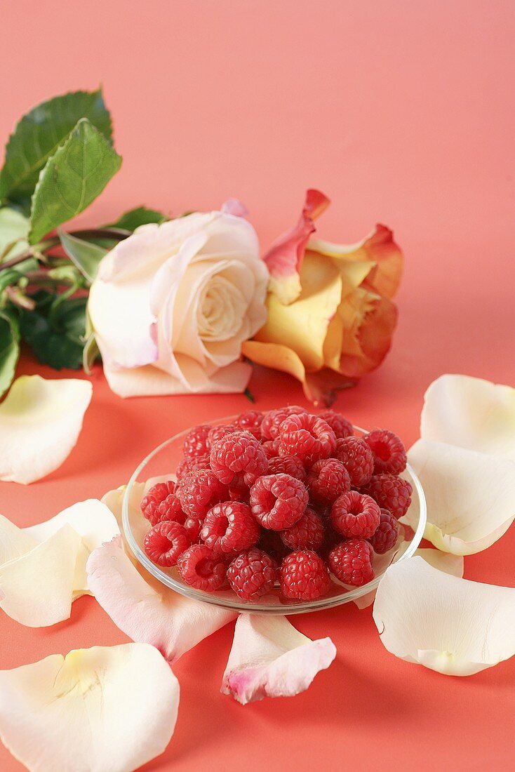 Raspberries with rose petals and roses