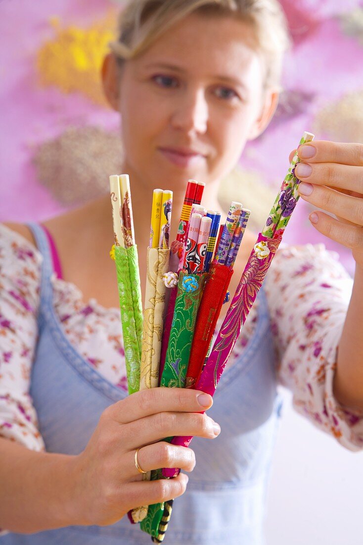 Woman holding a selection of different chopsticks