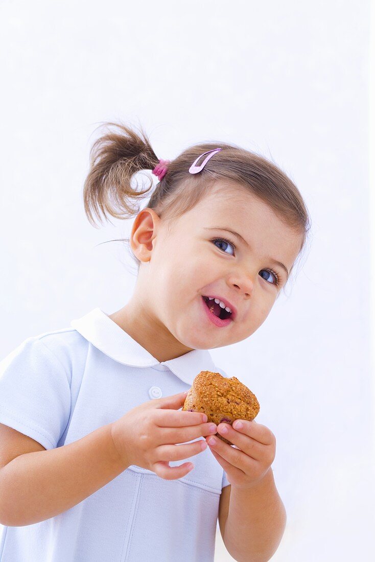 Kleines Mädchen hält Muffin