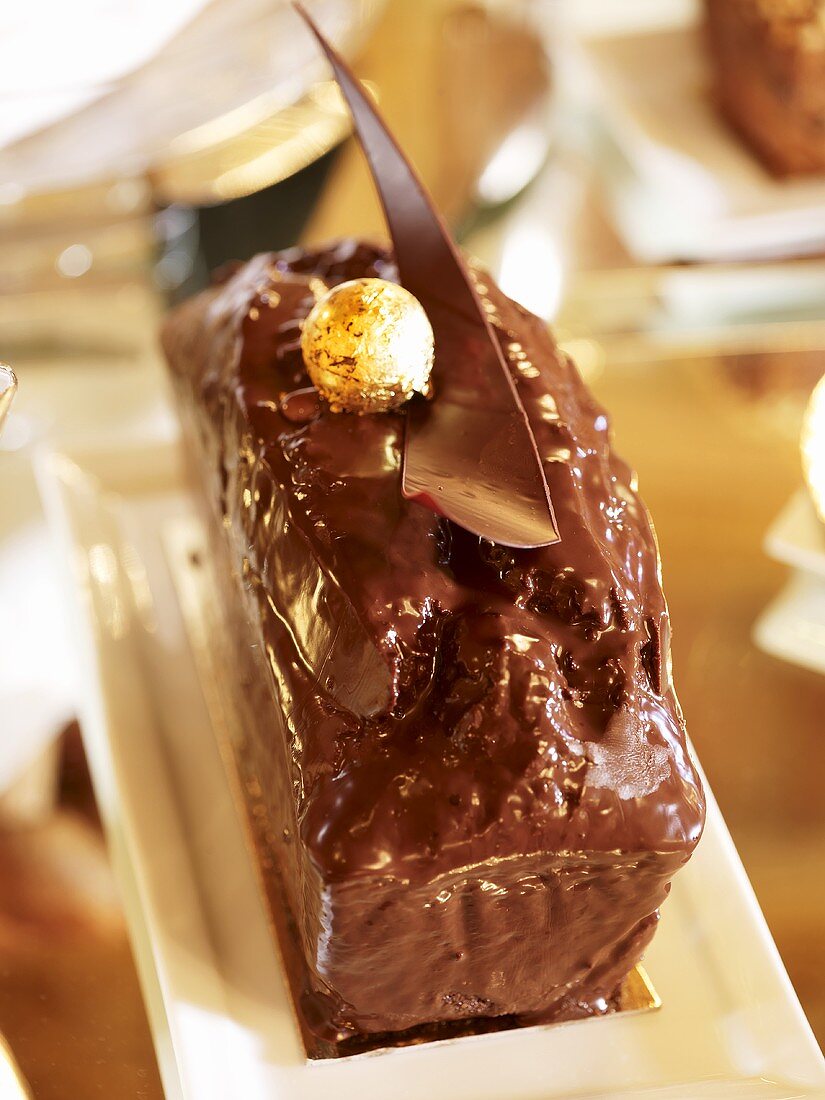 Rührkuchen mit glänzender Schokoladenglasur und Goldkugel