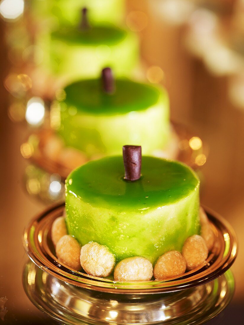 Moulded cream desserts with green glaze and mini-amaretti