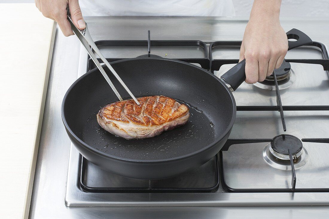 Frying duck breast in a frying pan
