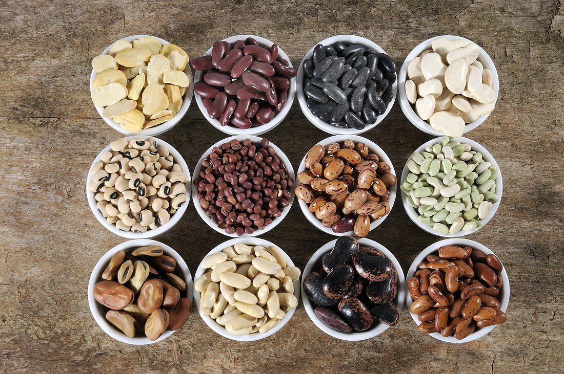 Various types of beans in bowls from above