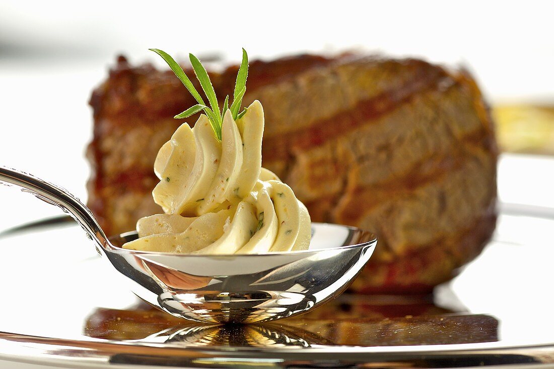 Dressierte Kräuterbutter auf Löffel vor Rindersteak