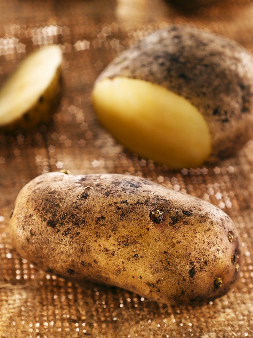 Potatoes, whole and partly sliced, on hessian