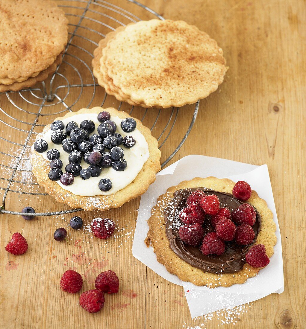 Biscuits topped with two sorts of cream and berries