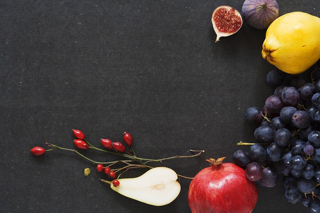 Still life with autumn fruit and branches of rose hips