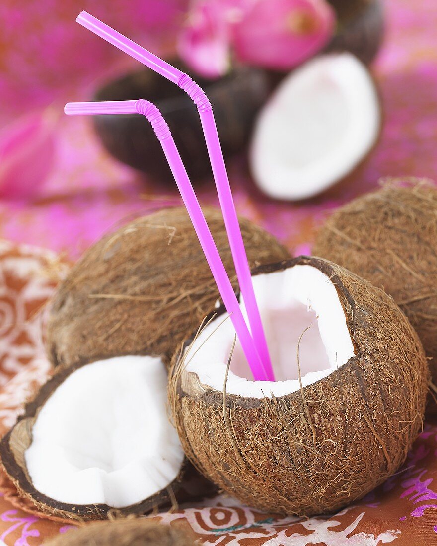 Opened coconut with straws