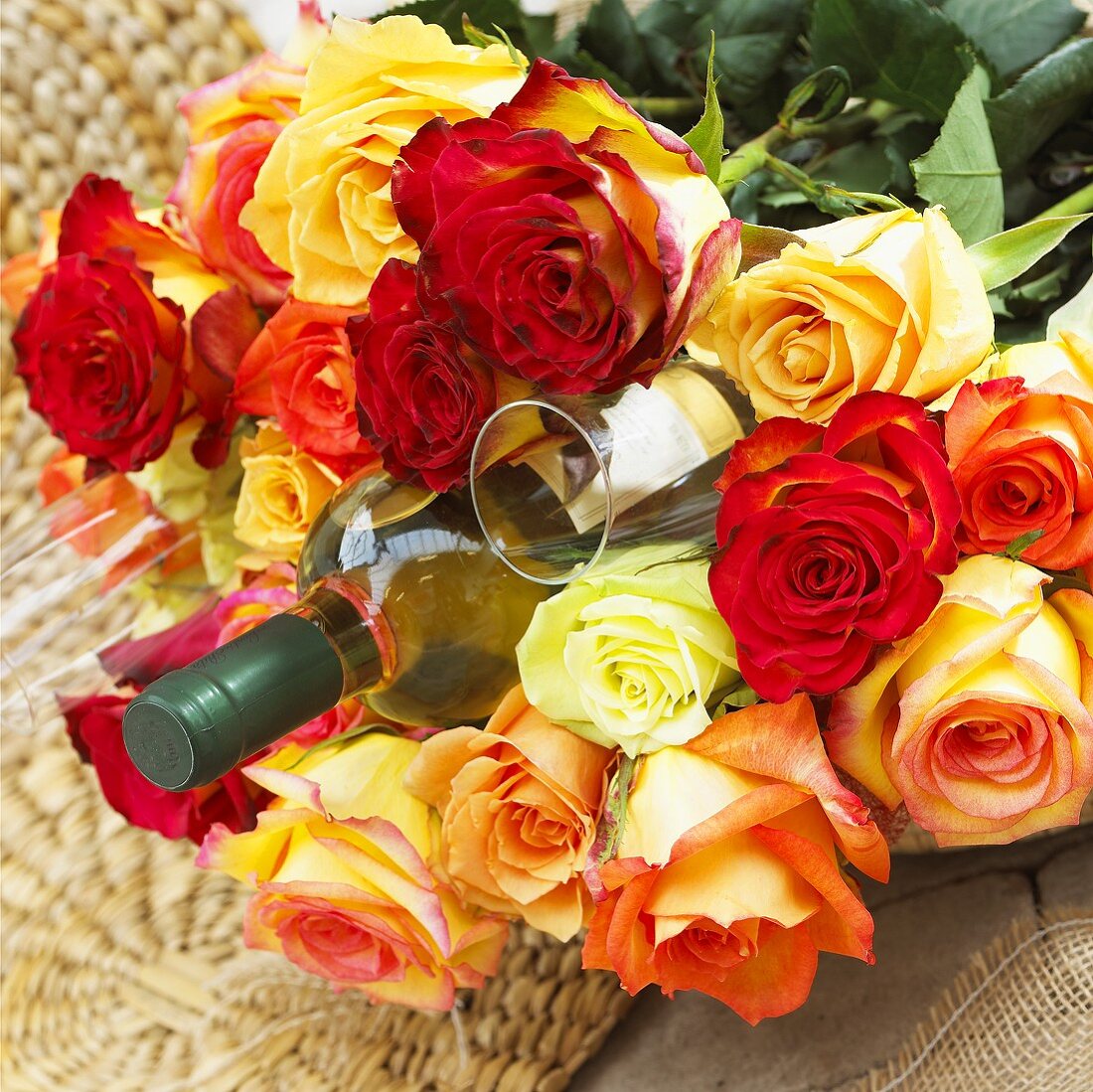 Bouquet of roses with bottle of white wine and glass