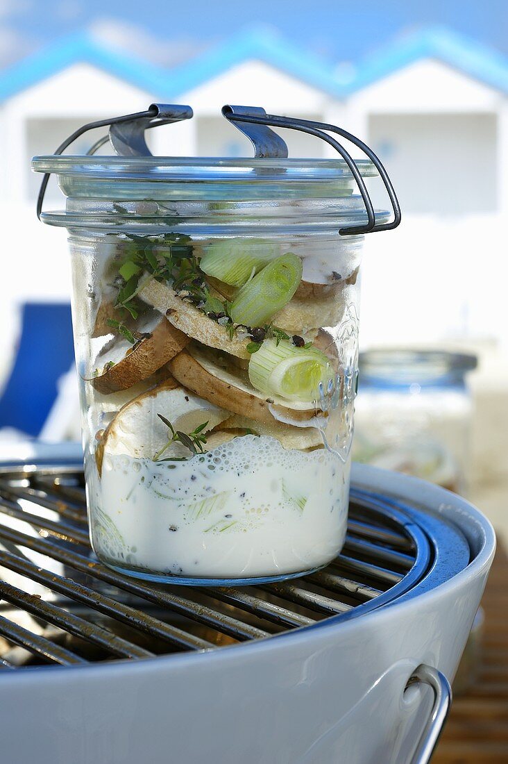 Mixed mushrooms in a creamy herb sauce in a preserving jar